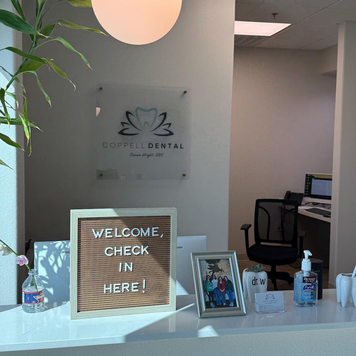Dental office reception area with 'Coppell Dental' sign and welcome message board.