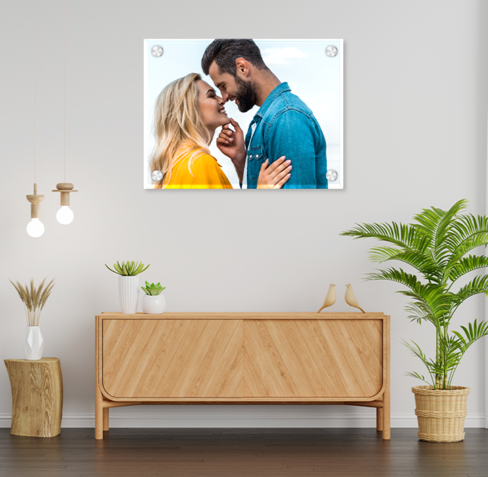 Wall art of a couple embracing on a white wall above a wooden console table.