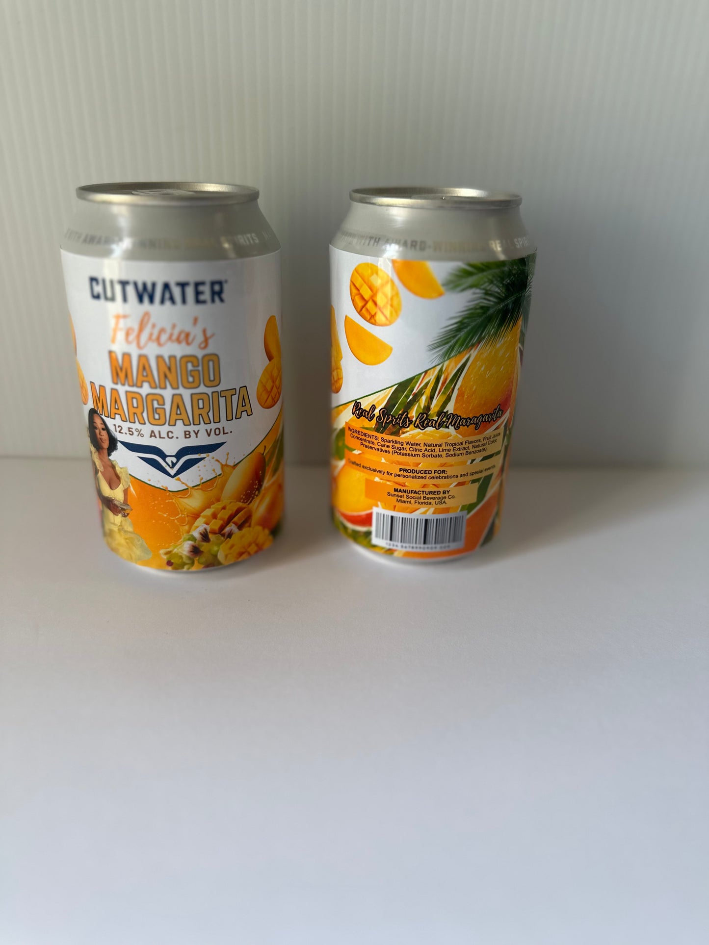 Two aluminum cans of Cutwater Felicia's Mango Margarita non-alcoholic beer, showing the front and back labels against a plain white background.