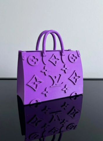 Purple handbag with brand logo on a reflective surface