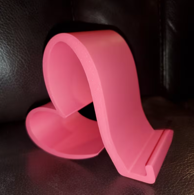 Pink phone stand on a dark textured surface
